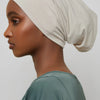 Model wearing a beige bamboo jersey tube hijab cap and a sage green top.