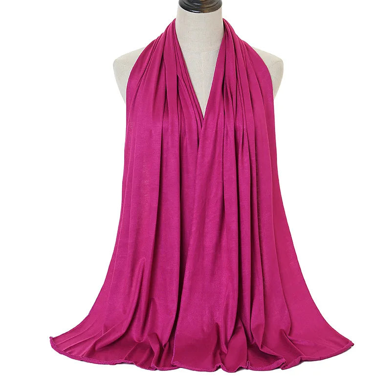 A vibrant magenta soft modal jersey hijab scarf draped around a mannequin's neck.