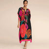 Una modelo viste un vestido kaftan negro con vibrantes estampados florales en rosa, naranja y verde.
