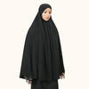 Eine Frau trägt eine elegante, schwarze, fließende Abaya mit innerer Hijab.