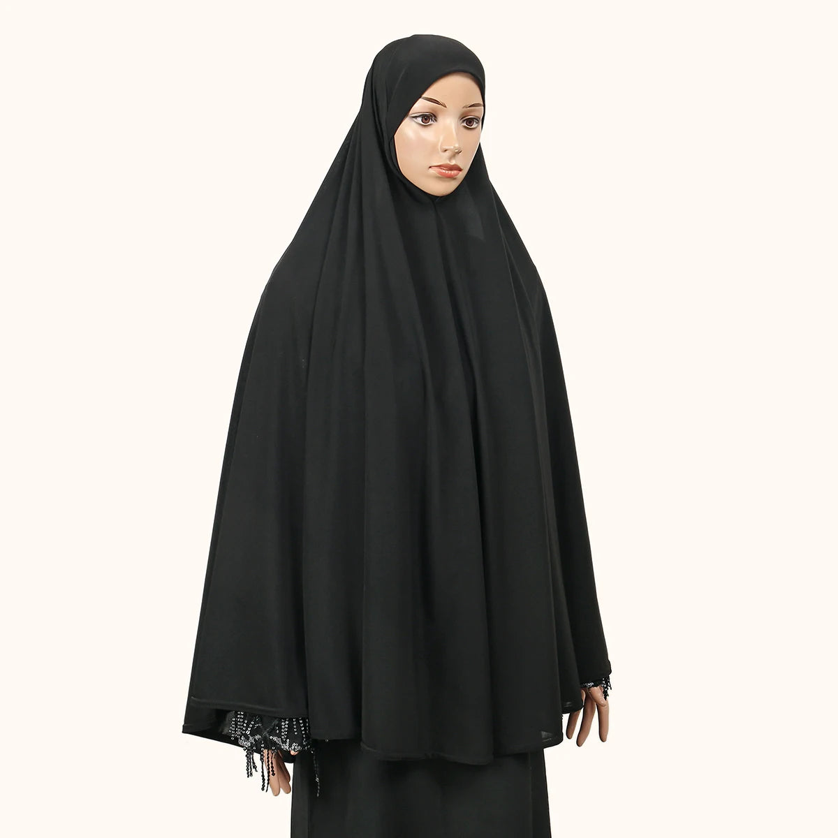 Eine Frau trägt eine elegante, schwarze, fließende Abaya mit innerer Hijab.