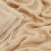 Primer plano de un chal hiyab de algodón rayón beige drapeado suavemente.