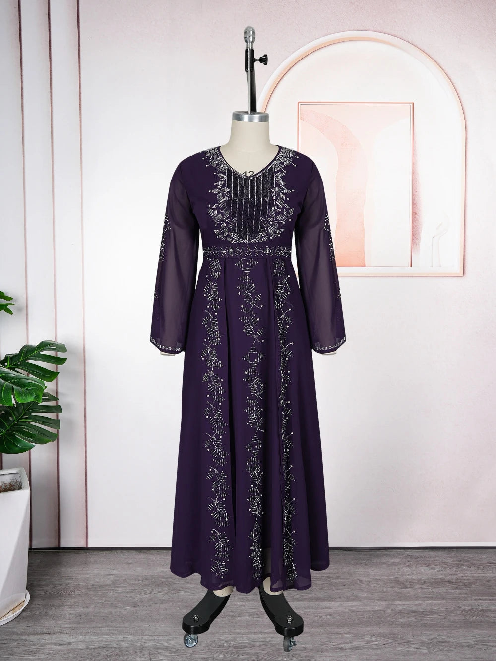 A long-sleeved purple sequin African party dress displayed on a mannequin.