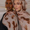 Deux femmes portant des foulards de hijab en polyester doux avec des motifs abstraits marron et beige.
