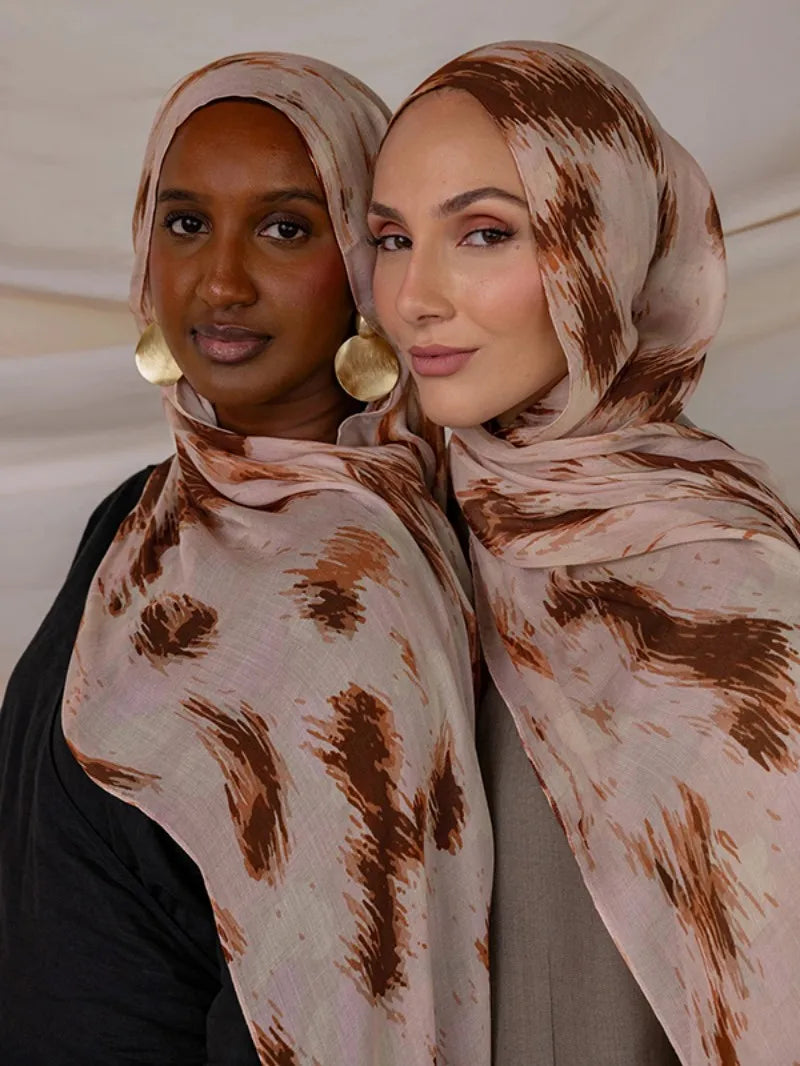 Deux femmes portant des foulards de hijab en polyester doux avec des motifs abstraits marron et beige.