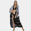 Eine Frau modelliert ein schwarz-weißes Tie-Dye Sommer-Strandkimono-Überkleid.