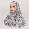 Cabeza de mujer con pañuelo hijab de estampado leopardo blanco y negro.