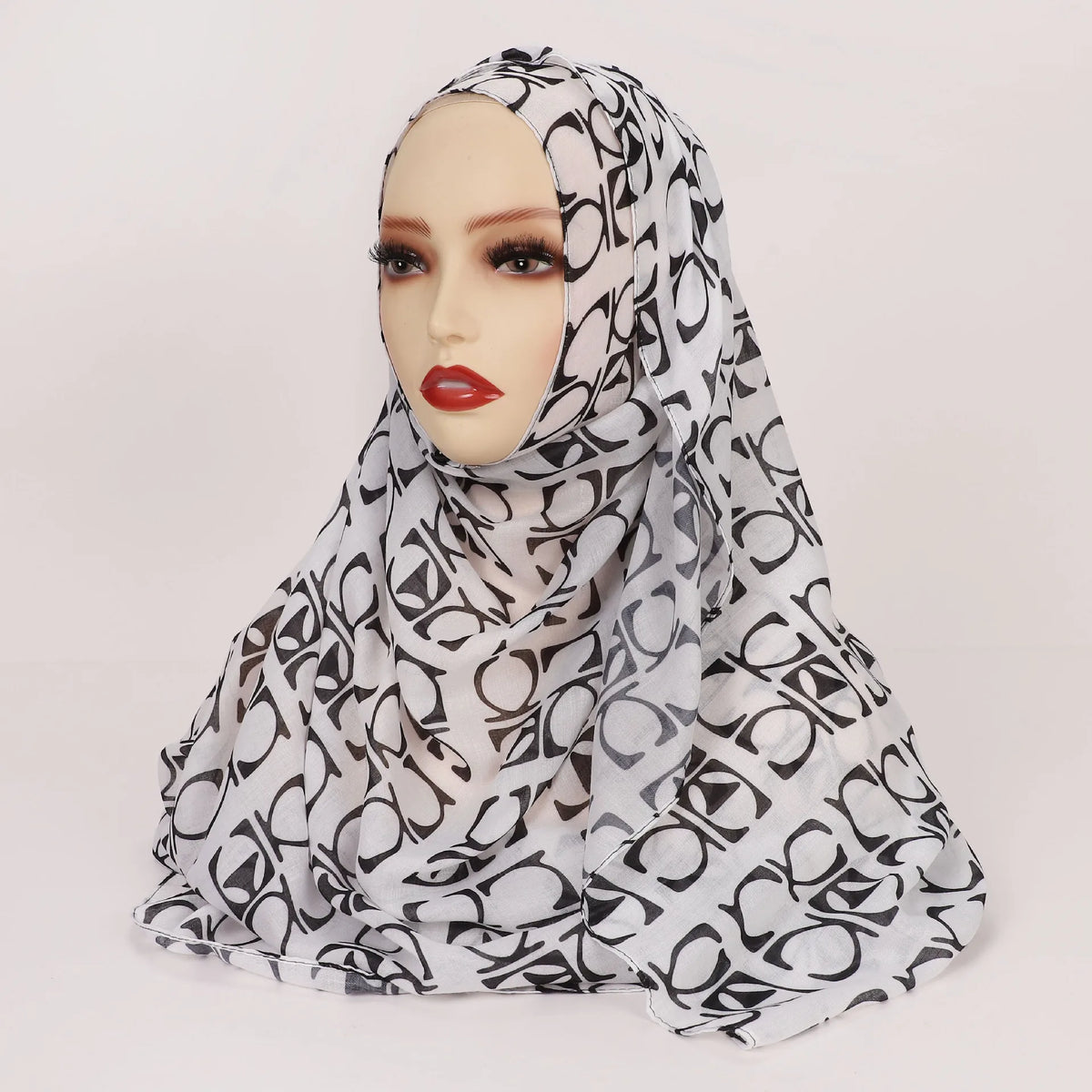 Cabeza de mujer con pañuelo hijab de estampado leopardo blanco y negro.