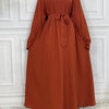 Fließendes, rostfarbenes Maxi-Abaya für Frauen mit zugebundenem Bund und schwarzem Hijab.