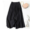 Schwarze Leinenmisch-Culotte mit weit geschnittenen Palazzo-Hosen, neben einem goldenen Ring und einer hellrosa Clutch.
