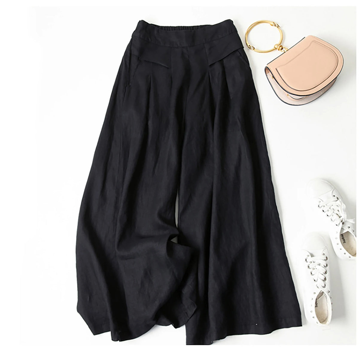 Schwarze Leinenmisch-Culotte mit weit geschnittenen Palazzo-Hosen, neben einem goldenen Ring und einer hellrosa Clutch.