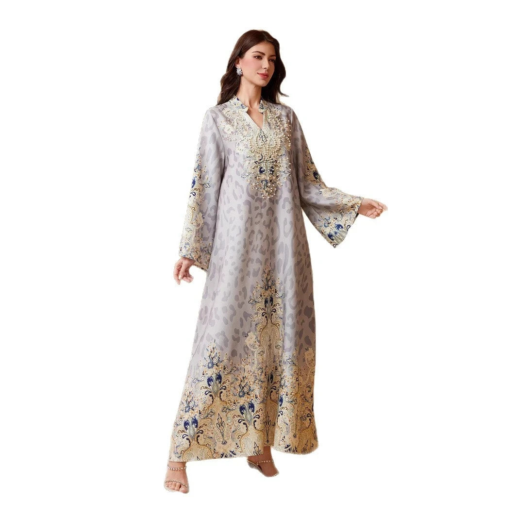 Una mujer vistiendo una abaya larga y fluida con estampado de leopardo gris claro y adornos de diamantes azules.