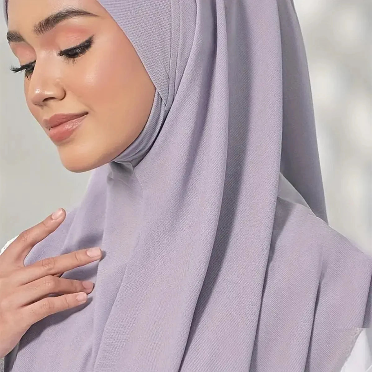 Gros plan sur un foulard turban en tissu coton chanvre instant de couleur violet clair porté par une femme.