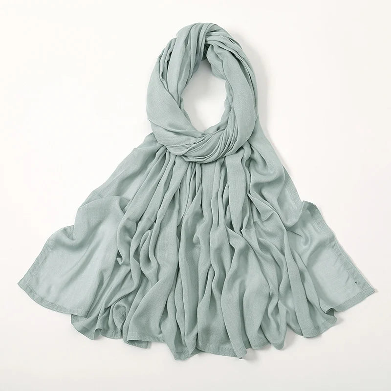 Pañuelo de hijab de modal rayon verde salvia, anudado y drapeado alrededor del cuello.