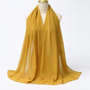 Fließender senffarbener Chiffon-Hijabschal um den Hals einer Mannequin