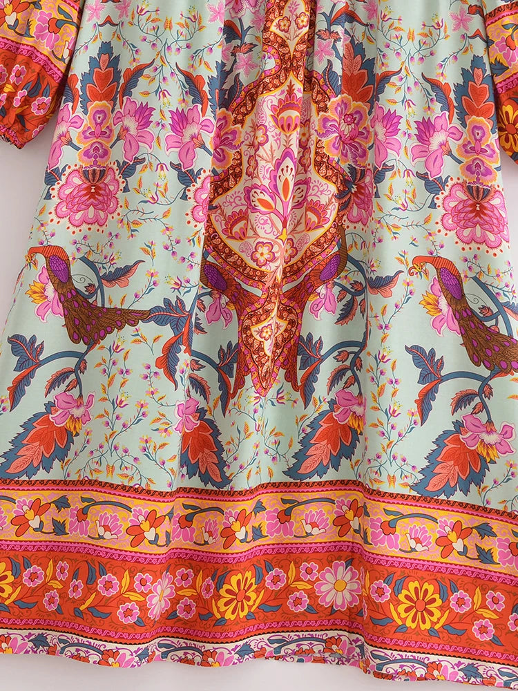 Vestido largo color menta claro con estampado floral vibrante en tonos rosa, naranja y rojo.