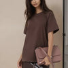 Una modelo vistiendo una camiseta básica de algodón marrón oversize y una falda de cuero.