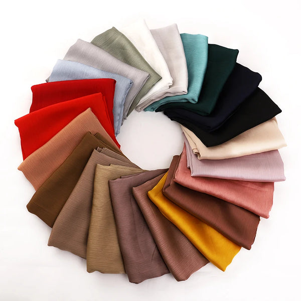 A circular arrangement of various colored satin crinkle hijab scarves for women.