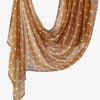 A flowing, sheer orange linen hijab scarf with white polka dots and lace trim.