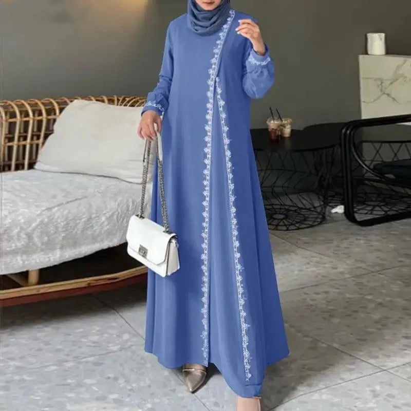 Eine Frau trägt ein langes, hellblaues Abaya-Kleid mit weißer Spitzenverzierung und hält eine weiße Handtasche.