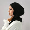 Eine Frau trägt einen schwarzen Instant-Falt-Hijab und ein weißes Oberteil, posiert im Profil.
