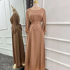 Langes, fließendes beiges Abaya-Kleid mit Gürtel und weiten Ärmeln auf einem Mannequin.