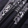 Close-up of a black and white portable braided prayer rug with compass design.