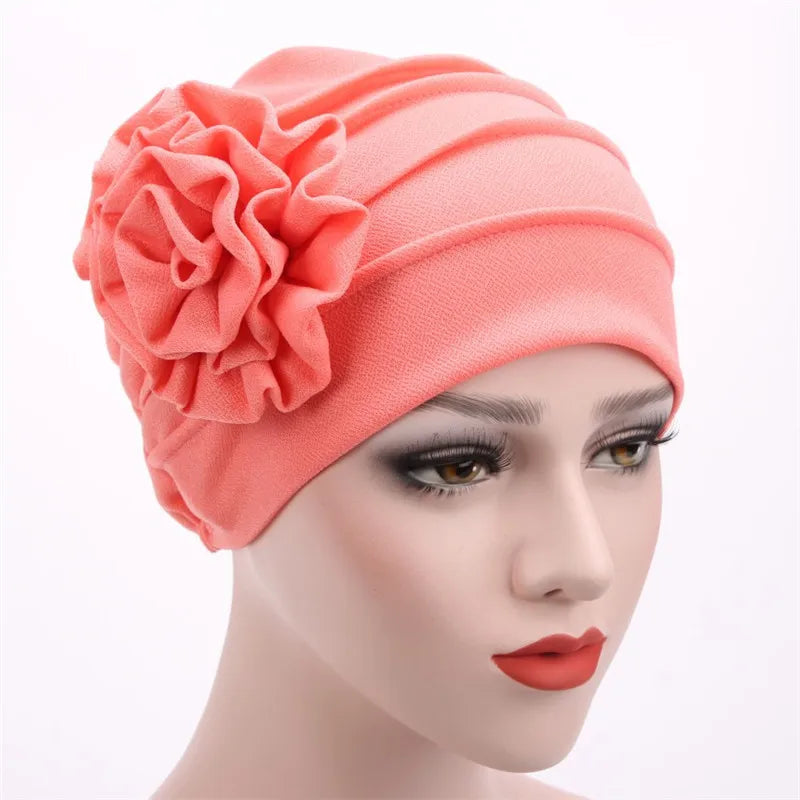 Korallrosa floral bestickter Hijab-Turban-Cap auf einem Mannequin-Kopf.