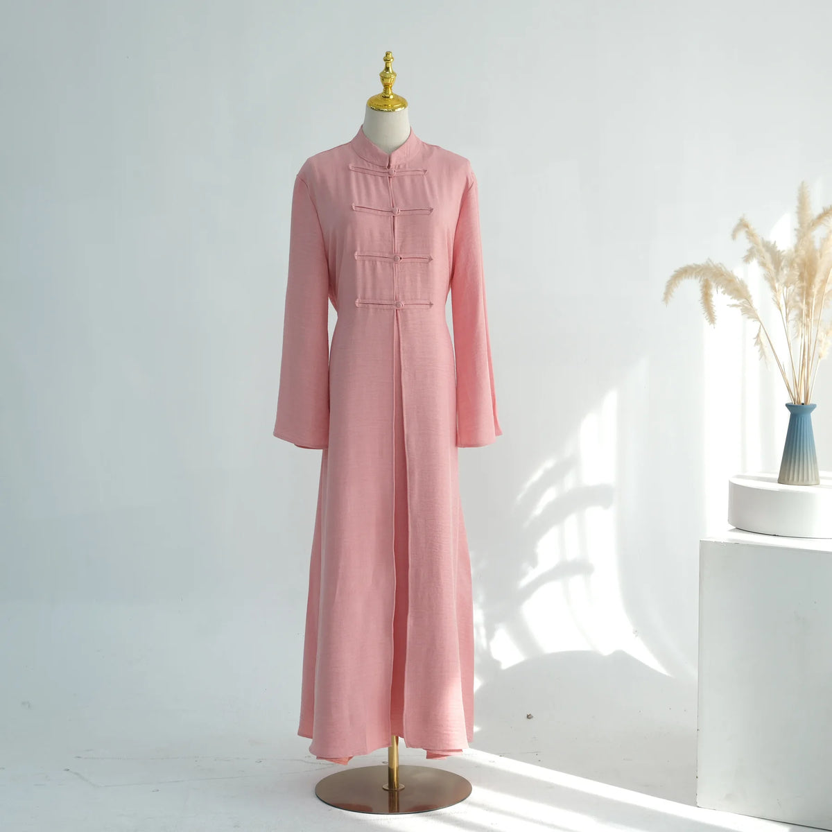 A pink elegant two-piece Arabic modest set displayed on a mannequin against a white background.