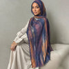 Una mujer vistiendo un pañuelo de hijab floral de acuarela bohemio sobre un vestido claro.