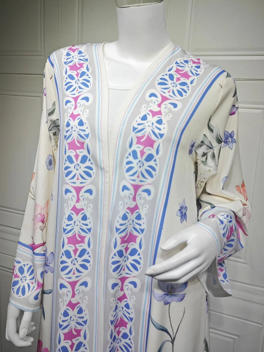 Vestido kaftan blanco con estampado floral en tonos rosa, azul y verde exhibido en maniquí.