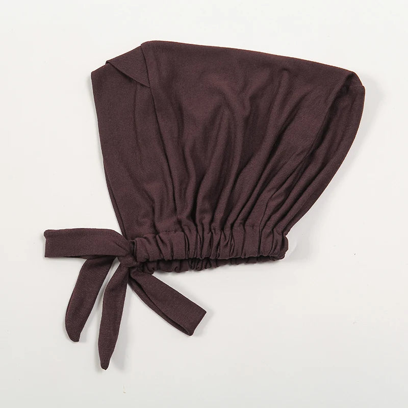 A dark brown adjustable cotton jersey inner hijab cap tied with a fabric bow.