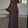 A full-length, dark brown elegant maxi dress with a high neckline and long sleeves displayed indoors.