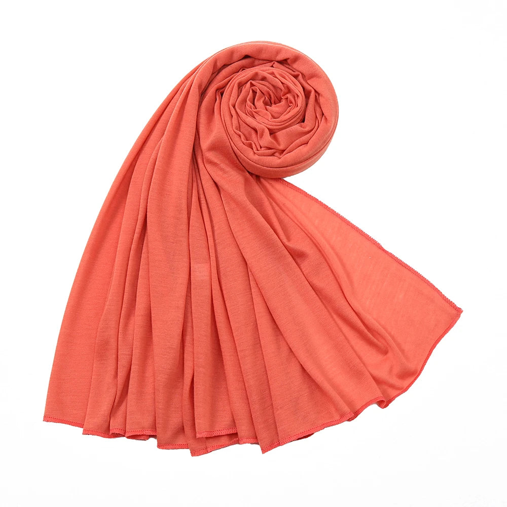 Terrakotta-orange Baumwoll-Jersey-Hijab-Schal in spiralförmiger Wicklung.