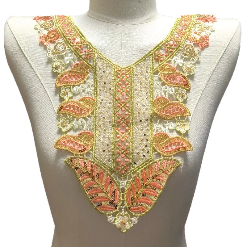 Parche de collar bordado con cuentas hecho a mano, con patrones florales rosas y dorados en una prenda blanca.