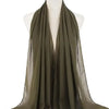 Ein drapierter olivgrüner Chiffon-Hijab-Schal auf einem Mannequin-Hals.