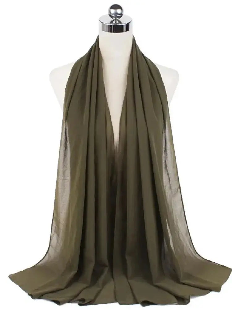 Ein drapierter olivgrüner Chiffon-Hijab-Schal auf einem Mannequin-Hals.
