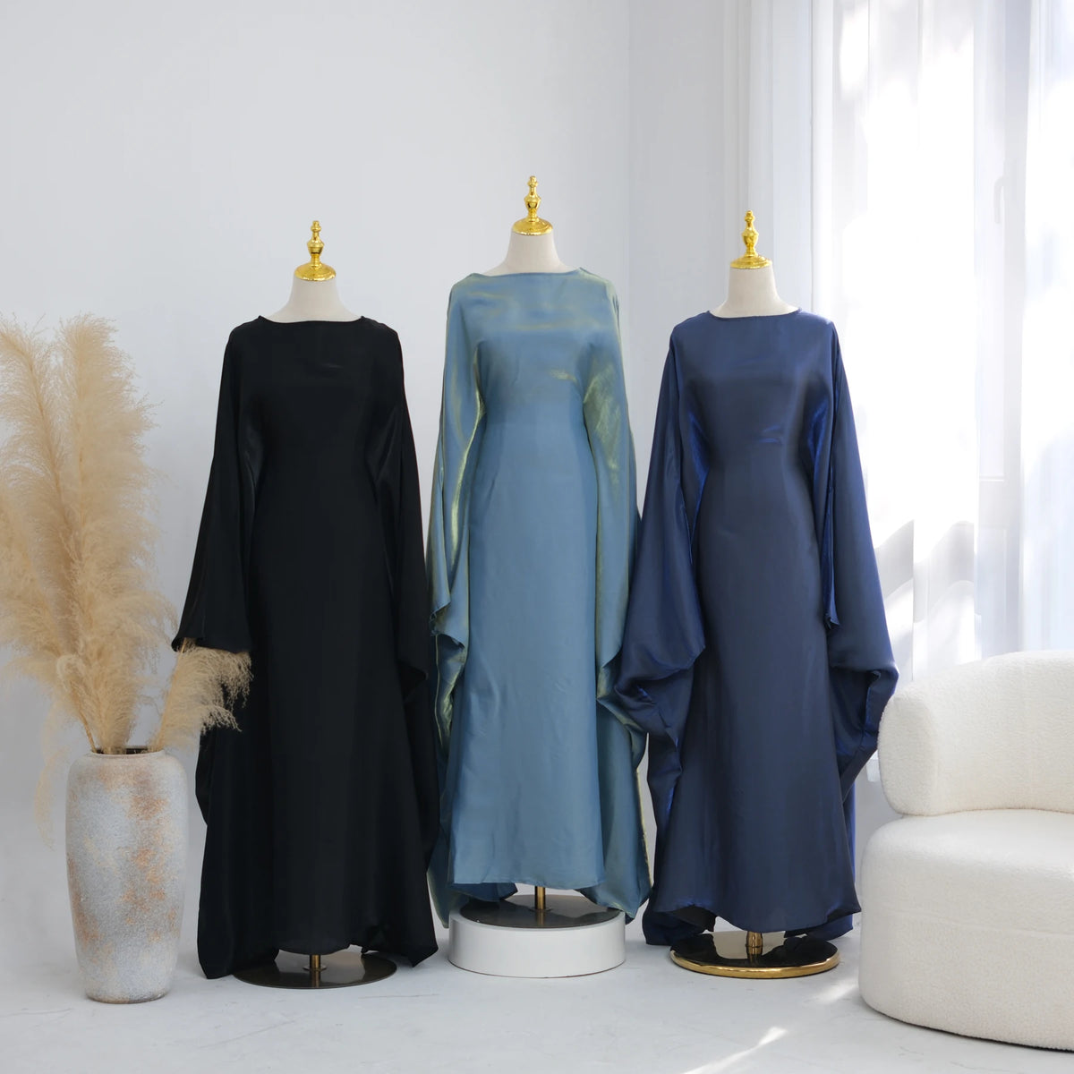 Darstellung eines eleganten Schmetterlings-Ärmel-Kaftans in schwarz-blauen Tönen auf Mannequins.