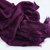 Écharpe hijab en coton viscose violet profond avec pompons drapée sur une surface blanche.