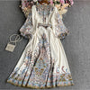 Weißes Maxi-Kleid mit Blumen-Spitze und Stickereien in Blau, Pink und Gold.