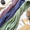 Eine Sammlung von Crinkle-Chiffon-Hijabs in Violett-, Blau- und Grüntönen auf einer weißen Oberfläche.