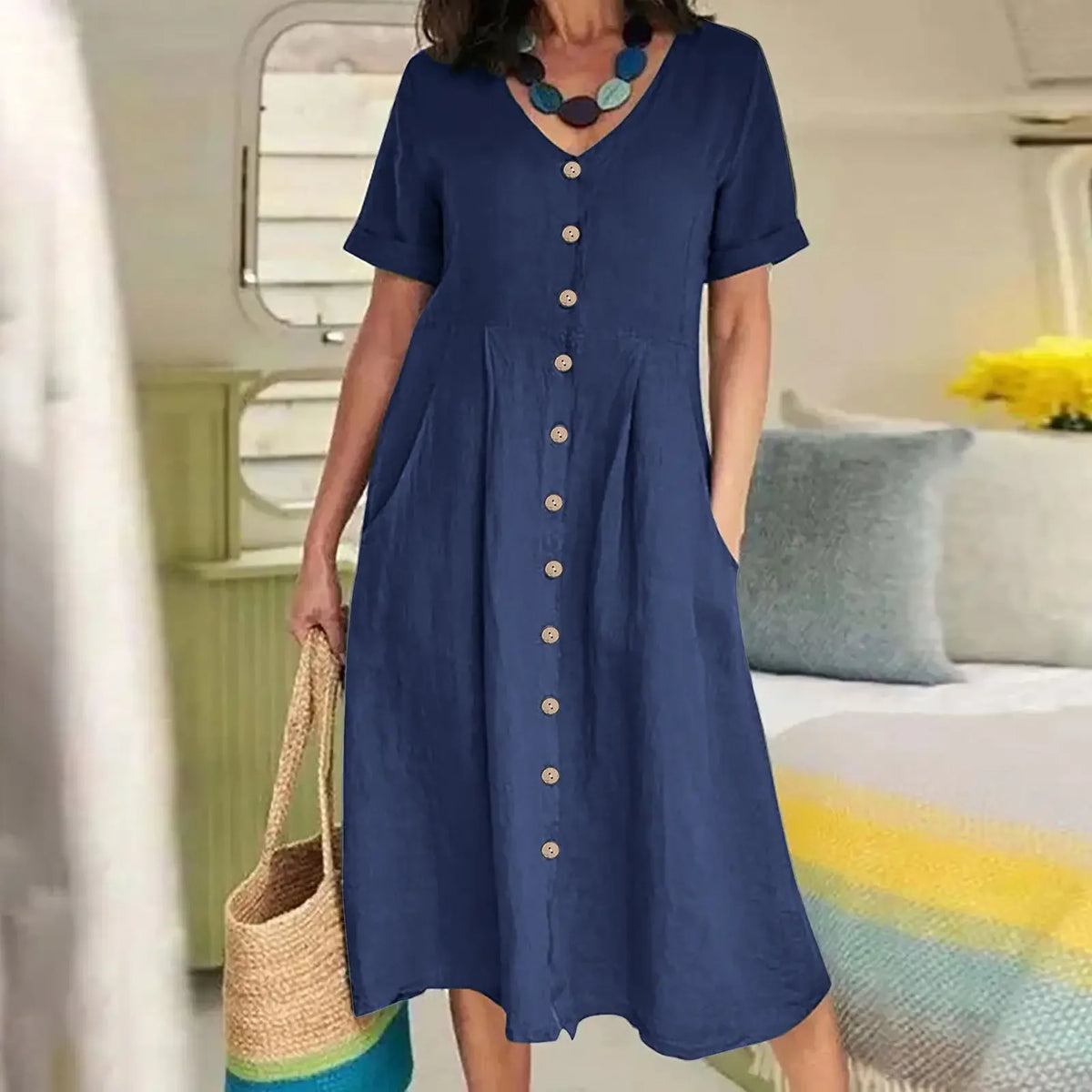 Marineblaues Baumwoll- und Hanf-V-Ausschnittkleid mit kurzen Ärmeln, aufgehängt.