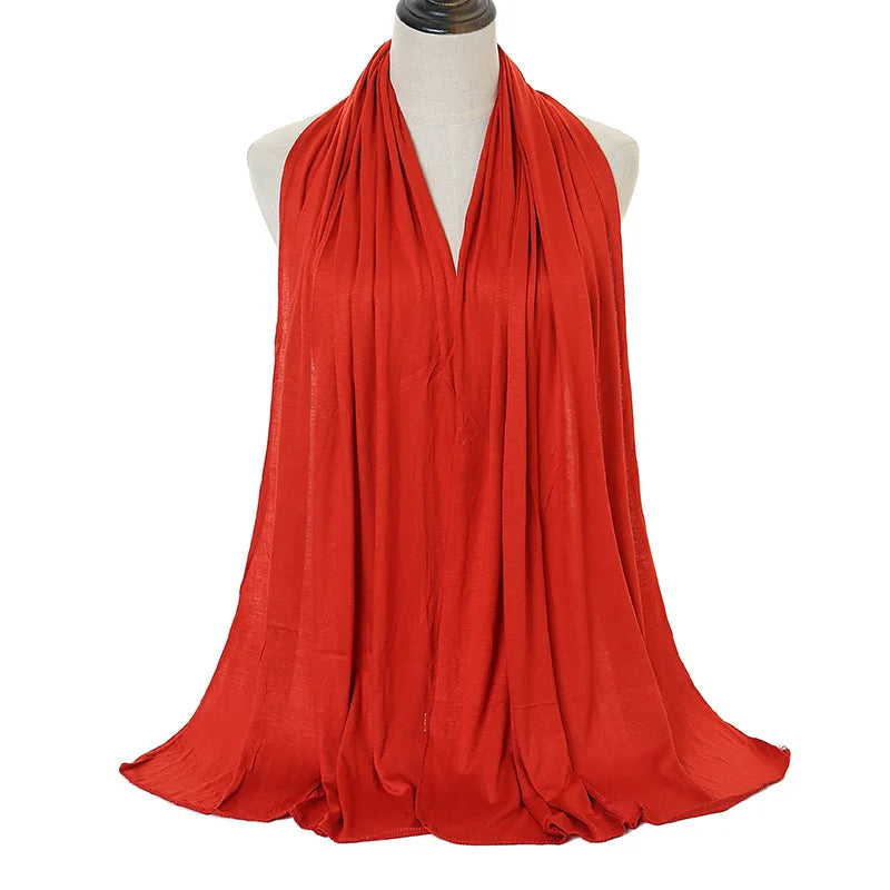 A vibrant red soft modal jersey hijab scarf draped around a mannequin's neck.