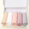Eine Box mit fünf gerollten Jersey-Hijab-Schals in Beige, Weiß, Pink, Mauve und Grau.