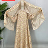 Una caftán abaya floral beige exhibida en un maniquí.