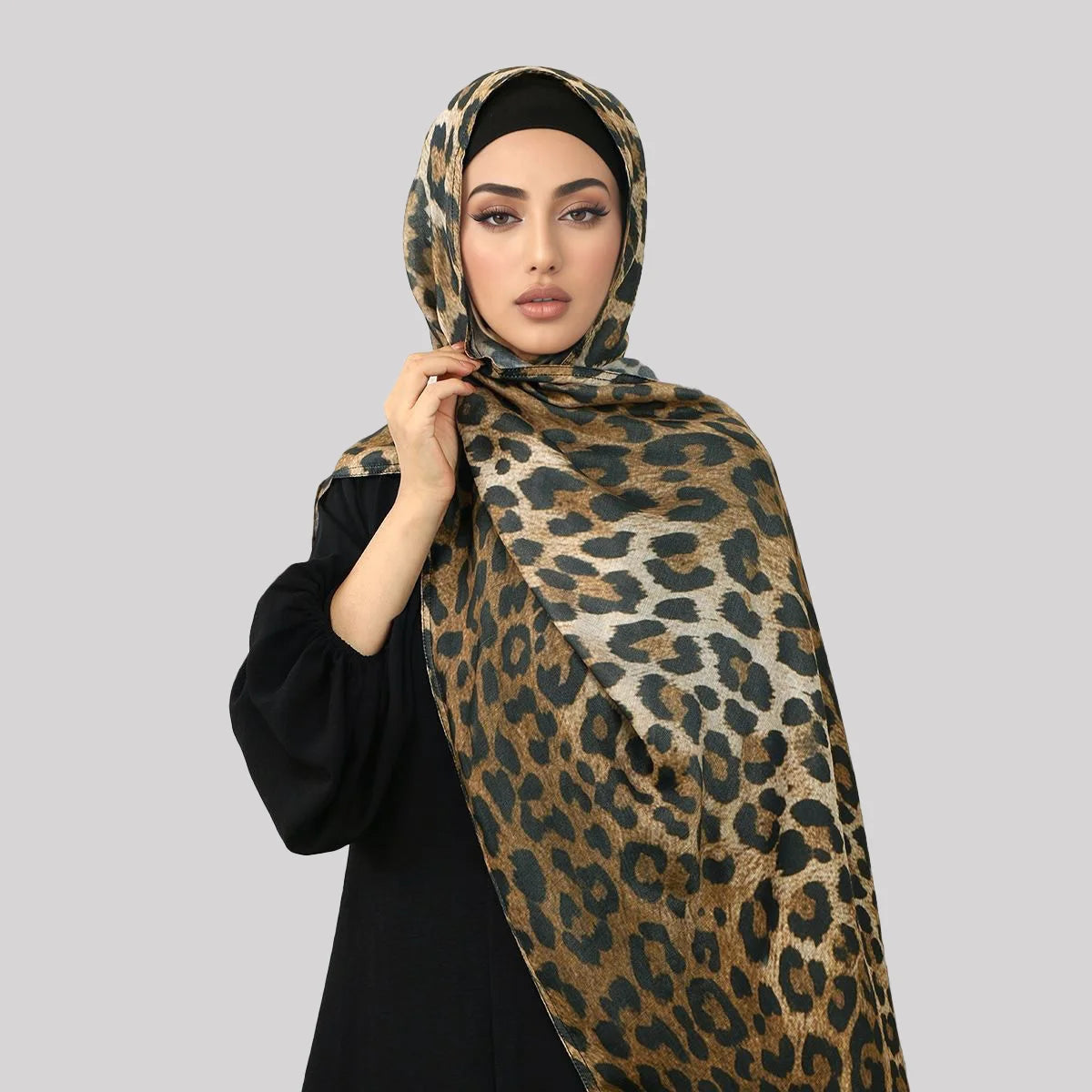 Eine Frau trägt einen braun-schwarz gemusterten Leoparden-Hijab aus Baumwoll-Leinen.