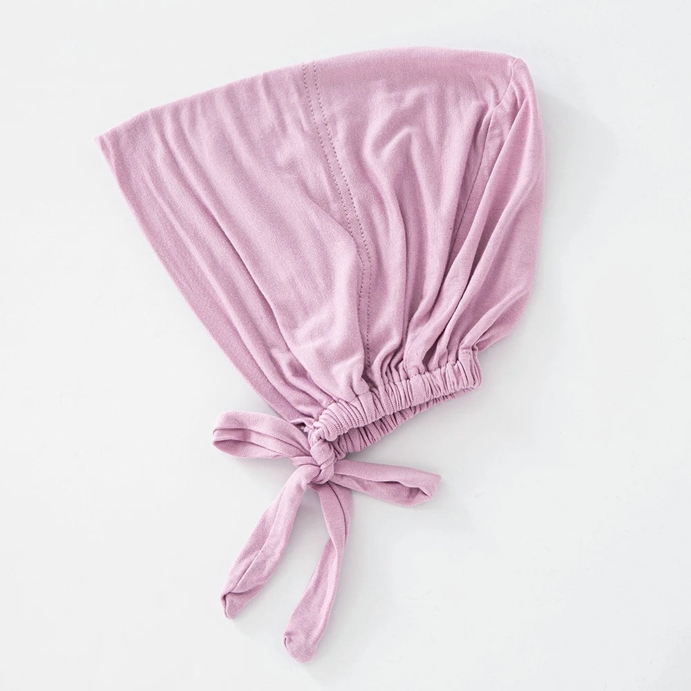 Weicher lilafarbener innerer Hijab-Bonnet aus zusammengefaltetem Stoff.