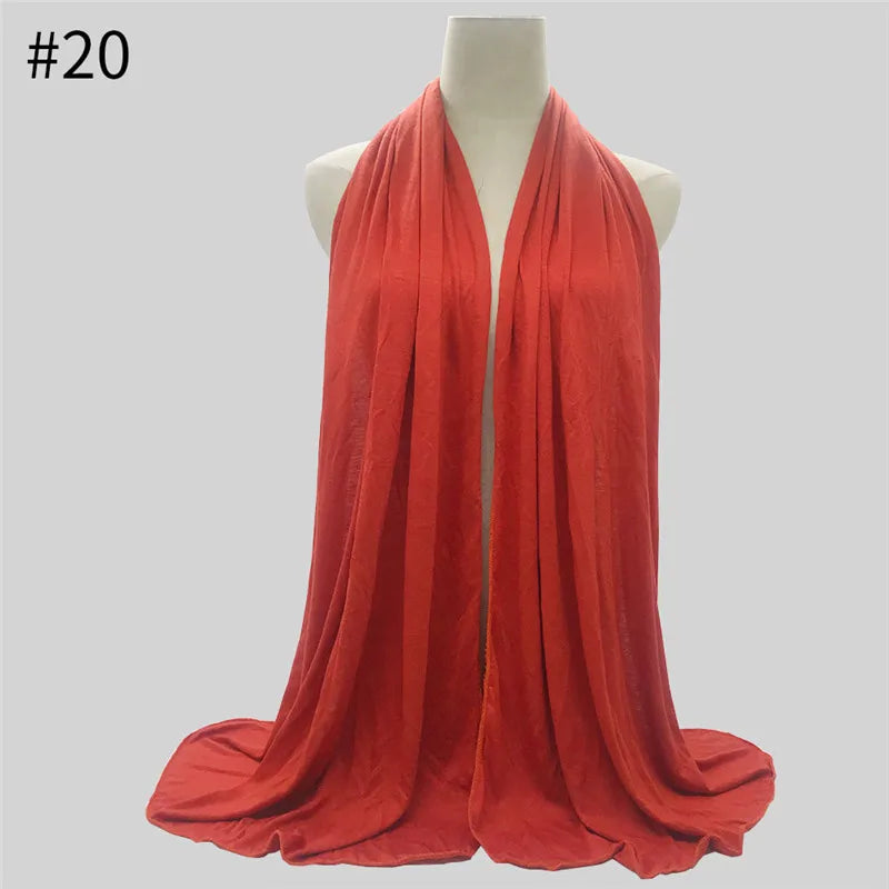 Leuchtend korallenrote Jersey-Hijab-Schal aus Baumwolle, drapiert auf einem Mannequin.
