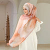 Eine Frau trägt einen eleganten bedruckten Baumwoll-Rayon-Hijab-Schal in sanftem Pfirsich- und Weißton.