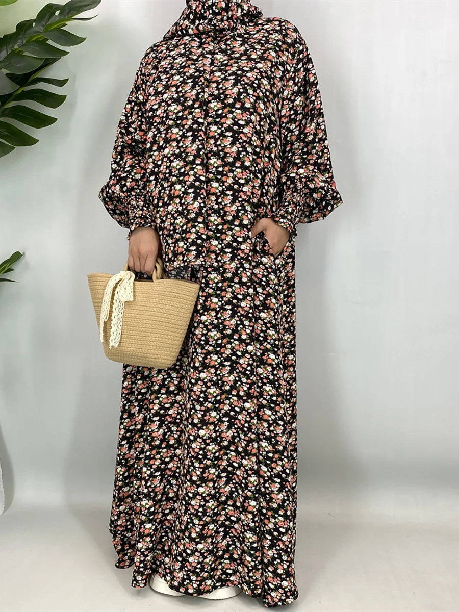 Una mujer vistiendo una elegante caftán abaya floral con mangas largas y tela estampada, sosteniendo una bolsa tejida.